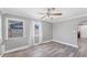 Bright living room featuring wood-look flooring, grey walls, and natural light from two windows at 513 25Th W Ave, Bradenton, FL 34205