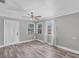 Living room featuring wood-look flooring, grey walls, a ceiling fan, and natural light from the windows at 513 25Th W Ave, Bradenton, FL 34205