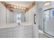 Well-lit bathroom featuring a large mirror, vanity with storage, and walk-in shower with grab bars at 5300 Gulf Dr # 501, Holmes Beach, FL 34217