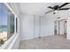 Bedroom featuring a ceiling fan and a peek into the kitchen area, with view of the beach at 5300 Gulf Dr # 501, Holmes Beach, FL 34217