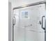 Glass-enclosed shower with grab bars and a window providing natural light at 5300 Gulf Dr # 501, Holmes Beach, FL 34217