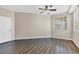 Bedroom with a ceiling fan, wood-look floors, and a bright window at 5552 Bentgrass Dr # 7-301, Sarasota, FL 34235