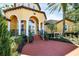 Community clubhouse entrance with brick path and columns and manicured landscaping at 5552 Bentgrass Dr # 7-301, Sarasota, FL 34235