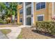 Close-up shot of the yellow condo entrance showcasing well-maintained walkways and lush greenery at 5552 Bentgrass Dr # 7-301, Sarasota, FL 34235