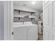 Laundry room equipped with washer, dryer, shelves, and water heater at 5552 Bentgrass Dr # 7-301, Sarasota, FL 34235