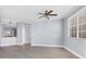 Open-concept living room with a ceiling fan and view into the kitchen at 5552 Bentgrass Dr # 7-301, Sarasota, FL 34235