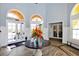 Community clubhouse lobby featuring tile flooring, arched doorways, and decorative floral arrangement at 5552 Bentgrass Dr # 7-301, Sarasota, FL 34235