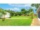 Spacious backyard featuring a large shed, brick path, and lush tropical landscaping at 5603 1St Avenue Dr Nw, Bradenton, FL 34209