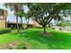 Serene backyard featuring lush grass, mature trees, and a community pool in a picturesque setting at 6030 7Th W Ave # 6030, Bradenton, FL 34209