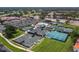 An aerial view shows the tennis courts, clubhouse, and parking amid lush surroundings at 6110 Country Club Way # 102, Sarasota, FL 34243