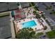 An aerial view shows the pool and tennis courts amid lush surroundings at 6110 Country Club Way # 102, Sarasota, FL 34243