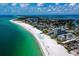 Breathtaking aerial view of the coastline, showcasing pristine beaches, turquoise waters, and stunning buildings at 6110 Country Club Way # 102, Sarasota, FL 34243