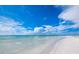Serene beach view with clear turquoise water and blue skies, offering a tranquil and relaxing atmosphere at 6110 Country Club Way # 102, Sarasota, FL 34243
