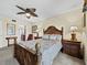 Well-decorated bedroom featuring wooden furniture, a ceiling fan, and plush bedding at 6110 Country Club Way # 102, Sarasota, FL 34243