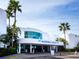 Modern building with curved glass windows, palm trees, and prominent signage for Marina Jack at 6110 Country Club Way # 102, Sarasota, FL 34243