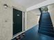 A cozy entryway leads to a flight of stairs to a second-floor unit with a welcome mat on the doorstep at 6110 Country Club Way # 102, Sarasota, FL 34243