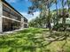 Building exterior with lush green lawn and mature landscaping at 6110 Country Club Way # 102, Sarasota, FL 34243