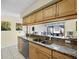 Well-lit kitchen featuring granite counters, stainless steel dishwasher, and double basin sink at 6110 Country Club Way # 102, Sarasota, FL 34243