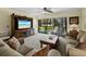 Inviting living room boasts comfortable seating, natural light, and a view to the outdoor landscape at 6110 Country Club Way # 102, Sarasota, FL 34243