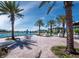 Inviting outdoor patio with comfortable seating arrangements, mature palm trees, and tranquil water views for relaxation at 6110 Country Club Way # 102, Sarasota, FL 34243