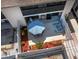 Aerial view of the private patio with a dining table with umbrella, sun loungers, and manicured landscaping at 6110 Country Club Way # 102, Sarasota, FL 34243