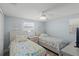 Bright bedroom with two twin beds, light blue walls, and a ceiling fan at 6150 Midnight Pass Rd # V4, Sarasota, FL 34242