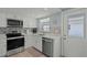 Well-equipped kitchen with modern stainless steel appliances, white cabinets, and stylish backsplash at 6150 Midnight Pass Rd # V4, Sarasota, FL 34242