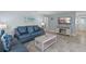 Comfortable living room with tile flooring, a plush blue sofa, and coastal-themed decor at 6150 Midnight Pass Rd # V4, Sarasota, FL 34242