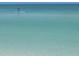 A solitary paddleboarder gliding across the calm, clear turquoise waters of the ocean at 6150 Midnight Pass Rd # V4, Sarasota, FL 34242