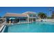 Community pool surrounded by lounge chairs and umbrellas for relaxing in the sun at 6150 Midnight Pass Rd # V4, Sarasota, FL 34242