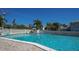 Inviting community pool with clear blue water and comfortable lounging area under a bright blue sky at 6150 Midnight Pass Rd # V4, Sarasota, FL 34242