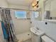 Bright bathroom featuring a tiled walk-in shower with glass block window, modern vanity, and neutral decor at 616 63Rd W Ave, Bradenton, FL 34207