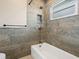 Tiled bathroom with a shower and tub combination and gray accent tiles at 6300 Midnight Pass Rd # 5, Sarasota, FL 34242