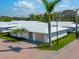Beautiful home with white tile roof, tan garage door, manicured lawn, and brick paver driveway at 6300 Midnight Pass Rd # 5, Sarasota, FL 34242