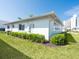 Exterior side view of home with manicured lawn, AC unit and small trimmed bushes at 6300 Midnight Pass Rd # 5, Sarasota, FL 34242