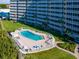 Community pool view surrounded by lush landscaping and high rise building at 6300 Midnight Pass Rd # 5, Sarasota, FL 34242