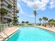 A clear and inviting pool view with palm trees and ocean views at 6300 Midnight Pass Rd # 5, Sarasota, FL 34242