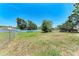 Well-maintained backyard with grass, mature trees, and chain-link fencing at 6332 7Th E Ct, Bradenton, FL 34203