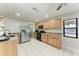 Well-lit kitchen featuring stainless steel appliances, wood cabinets, and tiled flooring at 6332 7Th E Ct, Bradenton, FL 34203