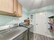 Well-equipped laundry room with a washer, dryer, and overhead cabinets at 6332 7Th E Ct, Bradenton, FL 34203