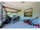 View of the enclosed porch with exterior furnishings and lawn maintenance equipment at 6332 7Th E Ct, Bradenton, FL 34203