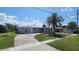 Inviting single-story home with a well manicured lawn, complemented by a mature palm tree at 6360 Jordan St, North Port, FL 34287