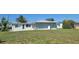 Back of house featuring a spacious yard, a gas propane tank, and new windows at 6360 Jordan St, North Port, FL 34287