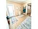 Inviting entryway with light wood floors and a decorative ladder with blue towels next to the door at 72 4Th Ave # 72, Venice, FL 34285