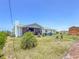 Spacious backyard with a screened lanai, lush landscaping, and a storage shed at 7690 Castleberry Ter, Englewood, FL 34224