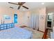Bright bedroom with hardwood floors featuring a colorful dresser and curtain, and a bathroom doorway at 7690 Castleberry Ter, Englewood, FL 34224