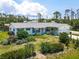 Charming single-story home with lush landscaping, manicured lawn, and a delightful light pink front door at 7690 Castleberry Ter, Englewood, FL 34224