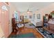 Cozy living room featuring hardwood floors, a ceiling fan, comfortable furniture, and vintage decor with a cheerful ambiance at 7690 Castleberry Ter, Englewood, FL 34224