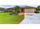 Charming single-story home featuring a well-manicured lawn, lush landscaping, and a two-car garage at 8402 13Th Nw Ave, Bradenton, FL 34209