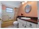 Full bathroom with tub, shower, white vanity, and peach walls at 8413 Lincolnshire Dr, Hudson, FL 34667
